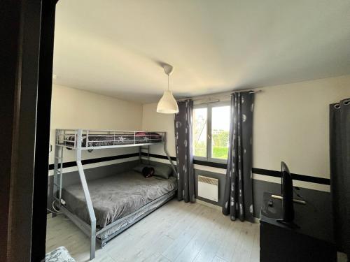 une chambre avec un lit superposé et une fenêtre dans l'établissement Maison 6 personnes, à Saint-Michel-sur-Orge