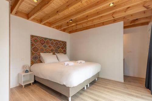 - une chambre avec un lit blanc et un plafond en bois dans l'établissement Lodge 