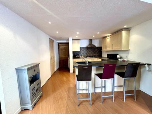 une cuisine avec une table et des chaises dans une pièce dans l'établissement Appartement Spacieux et Lumineux Proche Valence, à Saint-Péray