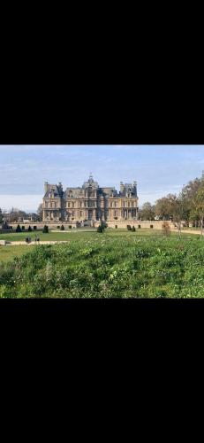 un grand bâtiment au milieu d'un champ dans l'établissement Charmant appartement au calme, à Maisons-Laffitte