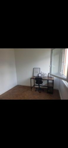 une pièce avec un bureau avec un ordinateur portable et une fenêtre dans l'établissement Charmant appartement au calme, à Maisons-Laffitte