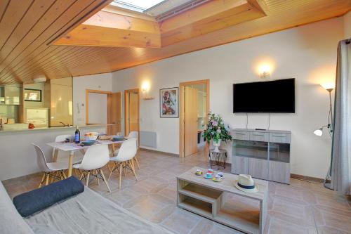 a living room with a table and a flat screen tv at Andorra Family Snow Apartment - Happy Rentals in El Tarter