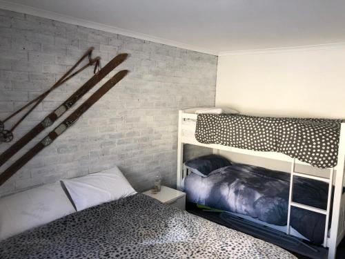 a bedroom with a bunk bed and a brick wall at Perfect Located Apartment in the heart of Hotham in Mount Hotham