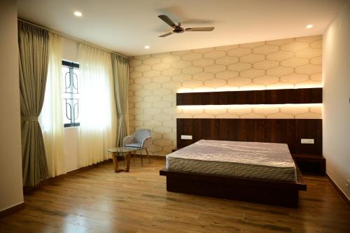 a bedroom with a bed and a ceiling fan at Hotel Dwaraka in Kaglipur