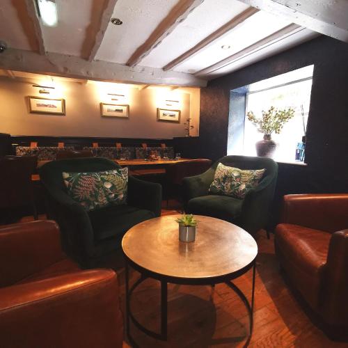 a bar with chairs and a table in a room at The Swinside Inn in Keswick