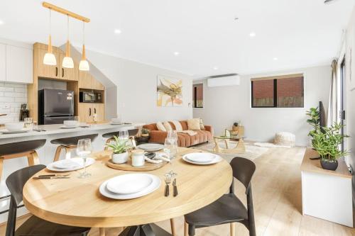 a dining room and living room with a table and chairs at Spacious Stunner! Central, King Bed -By KOSH BNB in Hamilton