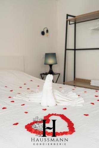 - un lit blanc avec des fleurs rouges dans l'établissement Magnifique Suite Luxe Jacuzzi Centre ville Nancy, à Nancy
