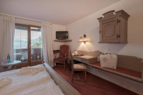 a bedroom with a bed and a desk with a desk at Mittelburg Wellnesshotel in Oy-Mittelberg