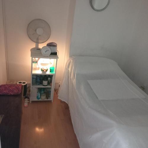 a bedroom with a white bed and a night stand at Wara in Kingston upon Thames