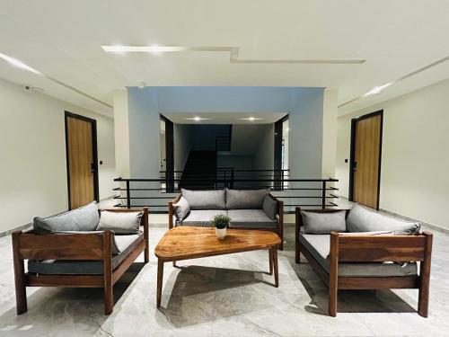 a living room with two couches and a table at Akoya Business Hotel Hyderabad Airpot in Shamshabad