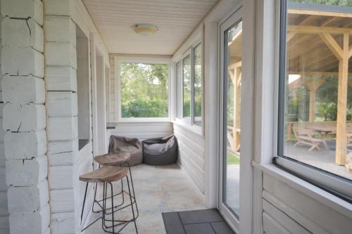 a screened porch with a chair and a table at Vantos Lapas Rezidencija in Trakai