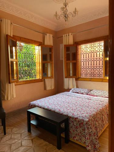 Oulad SnaguiaにあるTiny Ouasisのベッドと2つの窓がある寝室