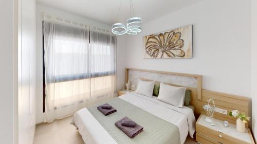 a bedroom with a large bed with purple towels on it at Holidoo Travel "Casa Maru" in San Javier