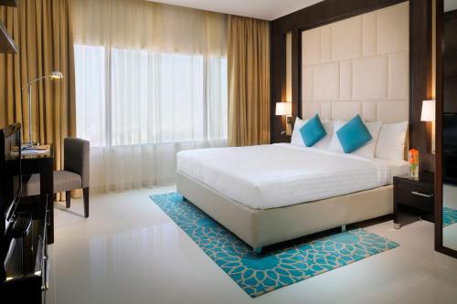 a hotel room with a large bed and a desk at Residence Inn by Marriott Manama Juffair in Manama