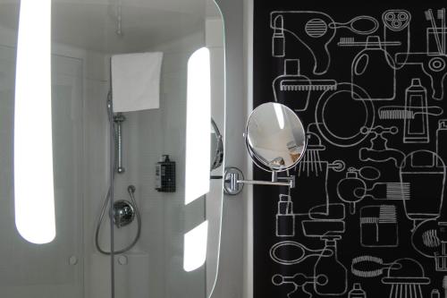 a bathroom with a shower and a mirror on a wall at Hotel ibis Rennes Centre Gare Sud in Rennes