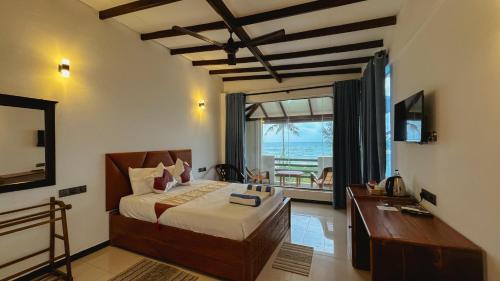 a bedroom with a bed and a view of the ocean at Ziegler Cottage in Negombo