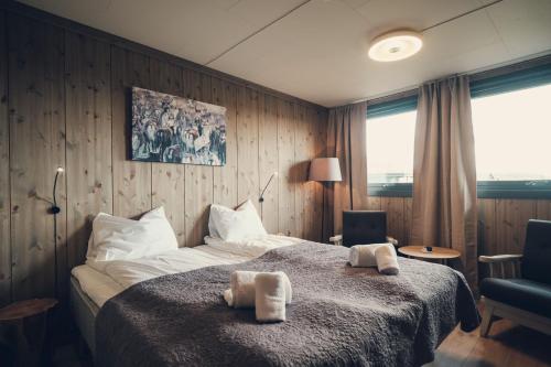 a bedroom with a bed with two towels on it at Spidsbergseter Resort Rondane in Venabygd