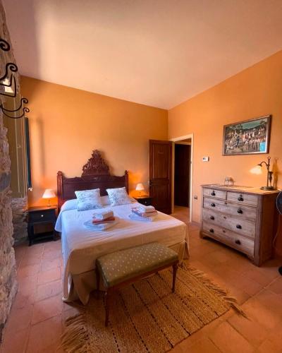 a bedroom with a large bed and a dresser at Can Clarós in Capmany