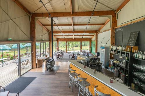 Cette grande chambre dispose d'un bar avec des chaises et des tables. dans l'établissement Lodge 