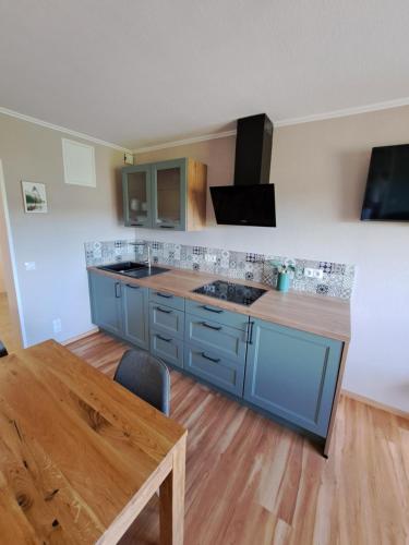a kitchen with blue cabinets and a wooden table at Ferienwohnung Wandereck in Boppard