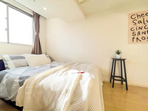 a bedroom with a bed with a white comforter at Shinjuku City, 2 Double Beds Apt, Free WiFi in Tokyo