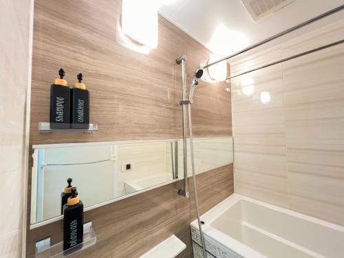 a bathroom with two black shampoo bottles in a shower at Shinjuku City, 2 Double Beds Apt, Free WiFi in Tokyo