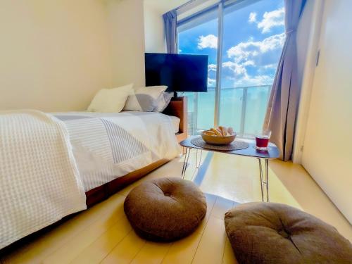 a bedroom with a bed with two ottomans and a window at Shinjuku City, 2 Double Beds Apt, Free WiFi in Tokyo