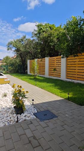 a garden with a fence and a patio with flowers at Gili Home Timisoara in Timişoara