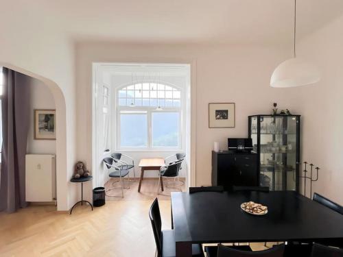 a living room with a black table and chairs at Villa AlexanderCharmante Wohnung mit Bergblick, Villa Alexander in Semmering