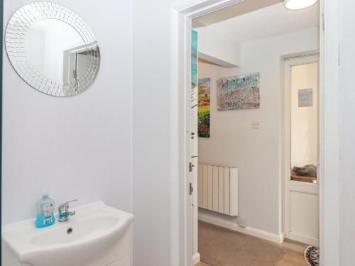 a white bathroom with a sink and a mirror at Brixham Breeze Cabin in Brixham
