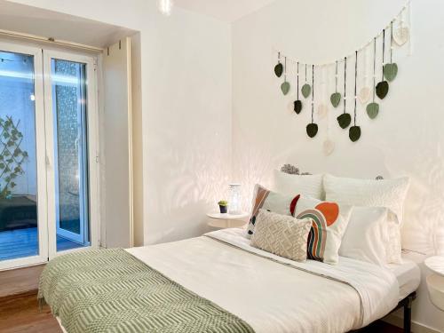a white bedroom with a large bed with pillows at PicaPau 59105AL in Lisbon