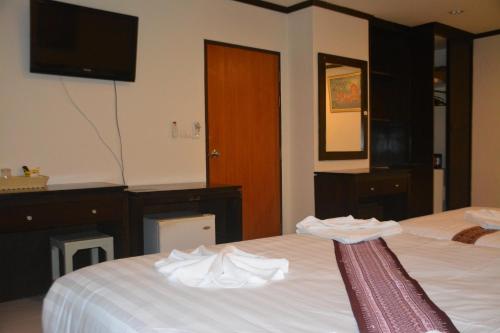 a hotel room with two beds and a television at Patong Moon Inn Residence in Patong Beach