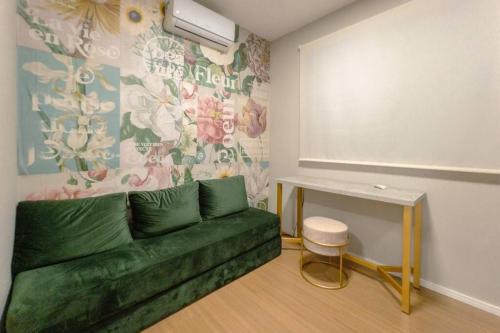 a living room with a green couch and a table at Apartamento Moderno AZ202-7 in Maringá