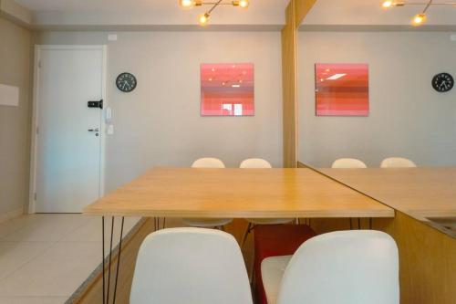 a conference room with a wooden table and white chairs at Apartamento Moderno AZ202-7 in Maringá