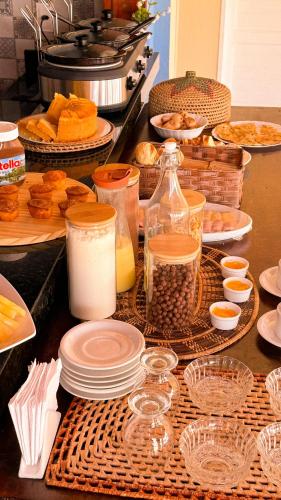 a buffet with plates and bowls of food on a counter at Malie Hotel in Águas Belas