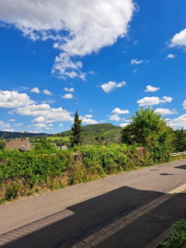 an empty road with a blue sky and clouds at Ferienwohnung Wandereck in Boppard