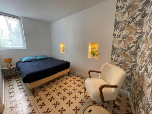 une petite pièce avec un lit et une chaise dans l'établissement Maisonnette quartier Arago, à Les Sables-dʼOlonne