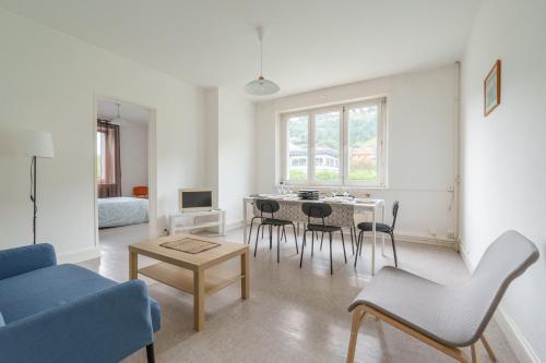 un salon avec un canapé bleu et une table dans l'établissement Les Proyes - Appt pour 6 avec jardin, à La Bresse