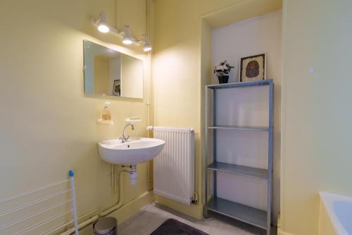 La salle de bains est pourvue d'un lavabo, d'un miroir et d'une étagère. dans l'établissement Les Proyes - Appt pour 6 avec jardin, à La Bresse