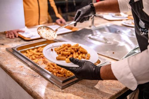 a person holding a plate of food on a counter at Chalet Cima Uomo in Passo San Pellegrino