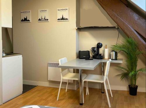 une cuisine avec une table et des chaises dans une pièce dans l'établissement Studio rénové gare Dijon, à Dijon