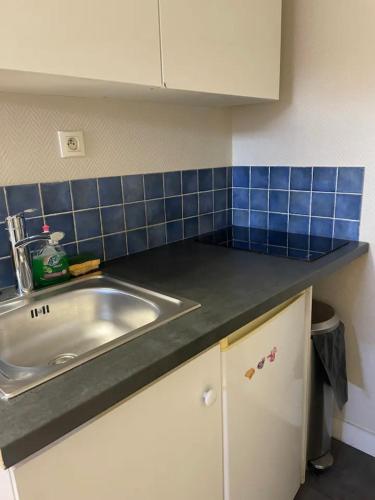 - un comptoir de cuisine avec évier et carrelage bleu dans l'établissement Studio rénové gare Dijon, à Dijon