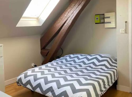 - un lit dans une chambre dotée d'une lucarne dans l'établissement Studio rénové gare Dijon, à Dijon