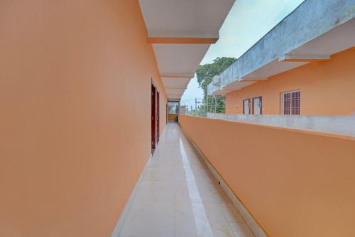 un pasillo vacío de un edificio escolar con paredes naranjas en Hotel O Siddhi Vinayak Hotel & Banquets, en Motīhāri