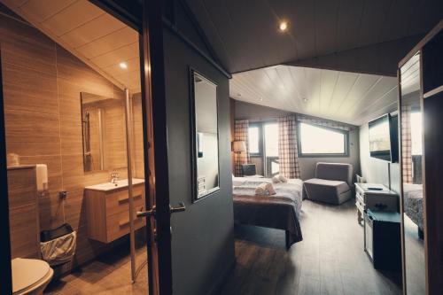 a bedroom with a bed and a bathroom with a sink at Spidsbergseter Resort Rondane in Venabygd