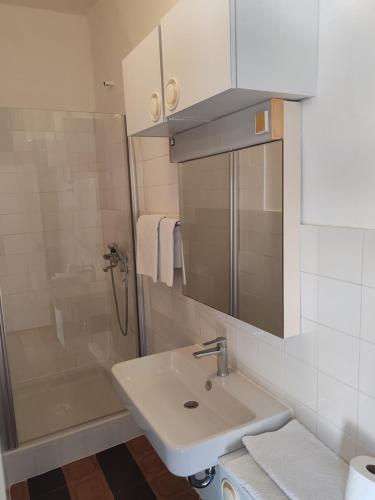 a white bathroom with a sink and a shower at RIBARIĆ in Banjol