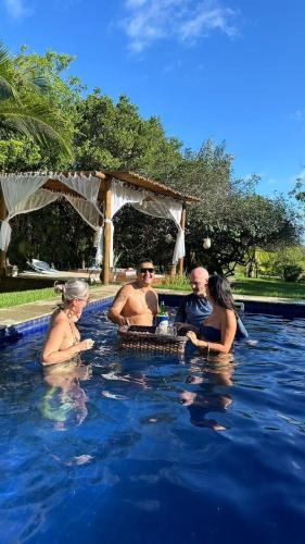 a group of people sitting in a swimming pool at Costa do Sauipe Casa dentro do complexo hoteleiro in Costa do Sauipe