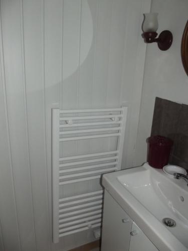 La salle de bains blanche est pourvue d'un lavabo et d'un lavabo blancs. dans l'établissement Maison charmante Trédrez-Locquémeau + Vue, à Coat-Tredrez