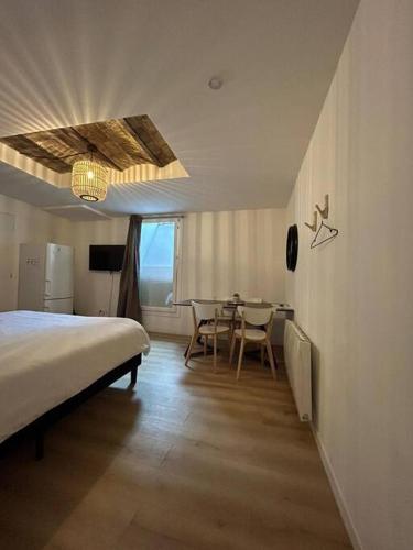 une chambre avec un lit et une table avec des chaises dans l'établissement CELLAR- Appartement Sous-Sol Atypique, à Reims