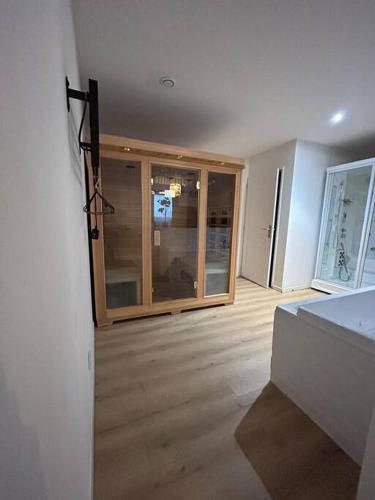 un salon vide avec une chambre dotée de portes en verre dans l'établissement CELLAR- Appartement Sous-Sol Atypique, à Reims